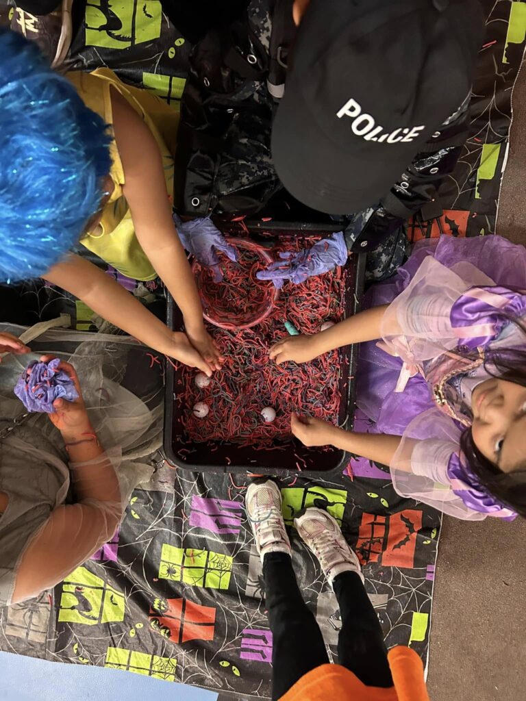 Children with colorful costumes engage in a hands-on activity